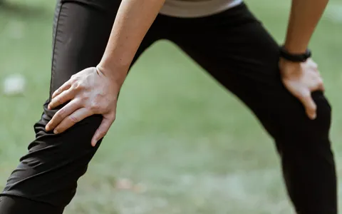 Atleta alongando a perna antes da atividade física