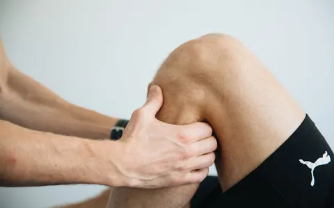 Fisioterapeuta avaliando a mobilidade do joelho de um paciente