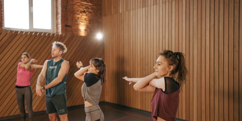 Pessoa se aquecendo com exercício de alongamento dinâmico em ambiente de treino
