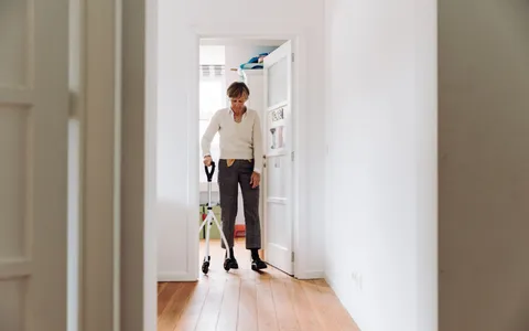Fisioterapeuta auxiliando paciente a caminhar com apoio durante a reabilitação