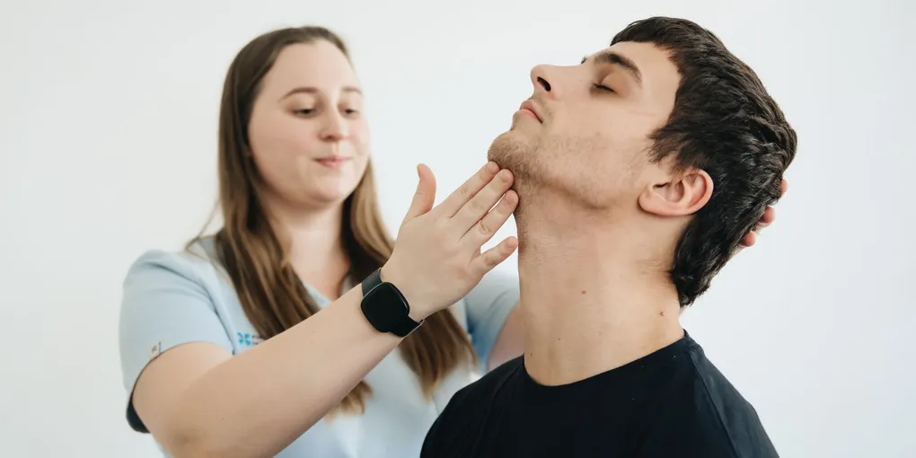 Fisioterapeuta examinando a coluna de um paciente durante avaliação
