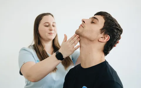 Fisioterapeuta examinando a coluna de um paciente durante avaliação