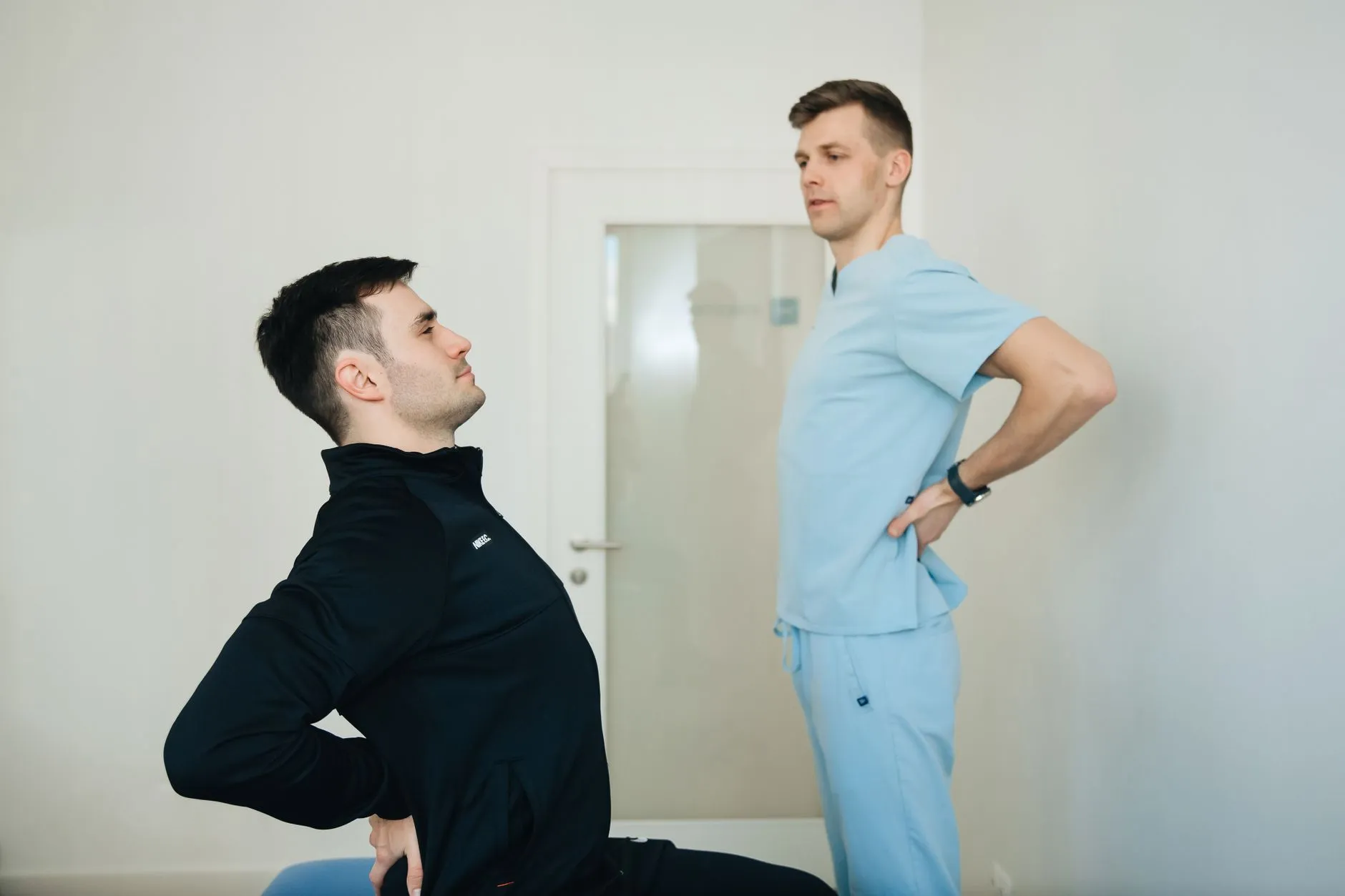 Fisioterapeuta orientando paciente durante exercício de fortalecimento lombar