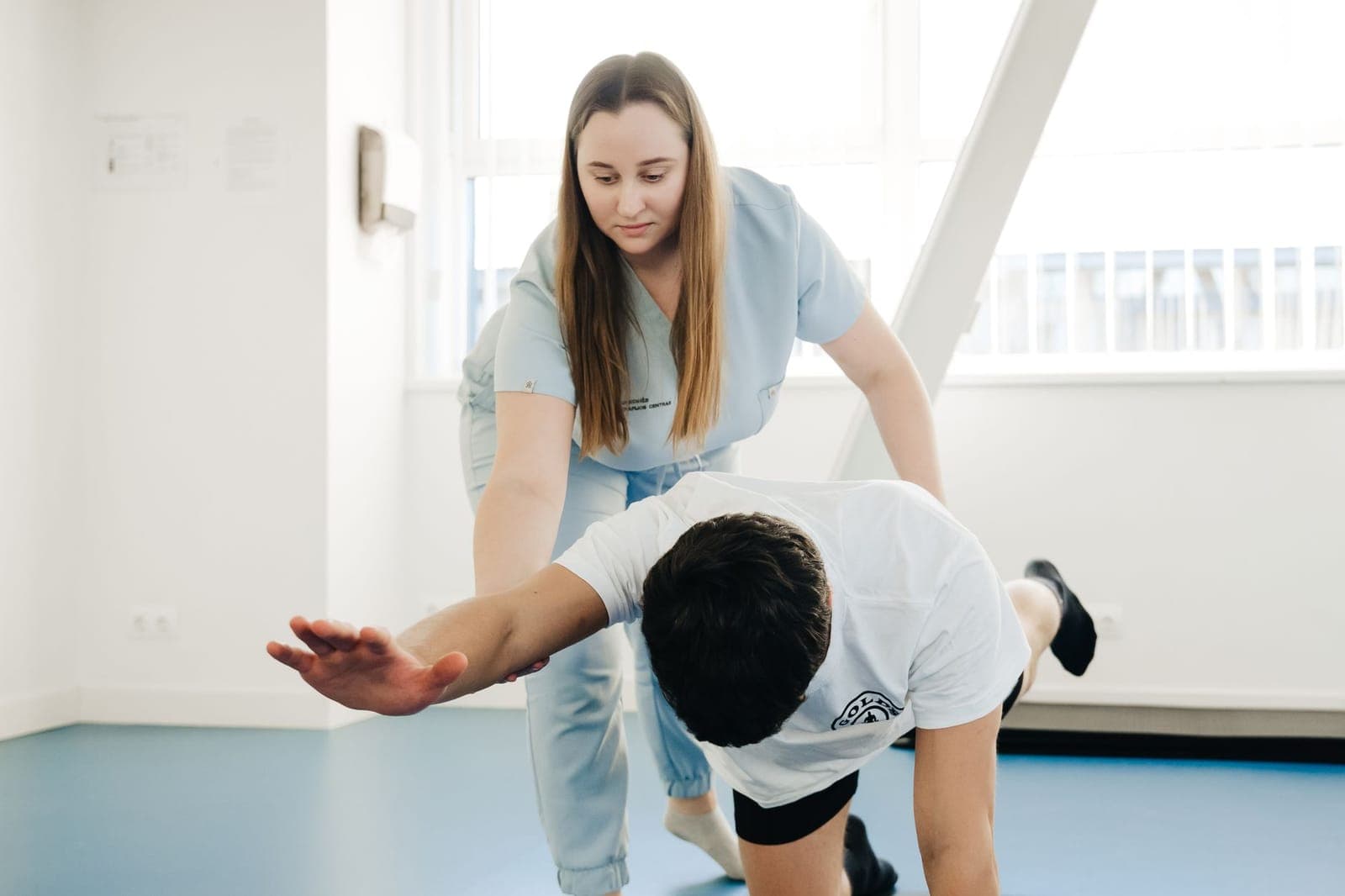 Fisioterapeuta acompanhando paciente em recuperação logo após uma cirurgia ortopédica