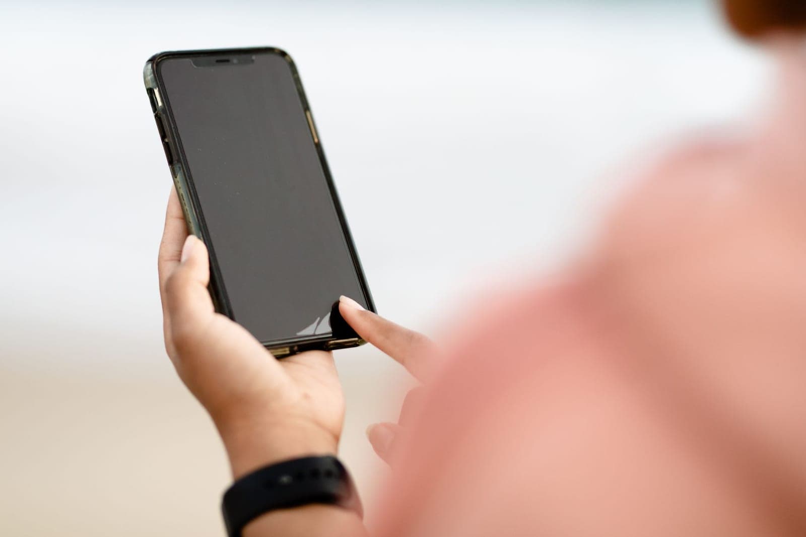Pessoa olhando para o celular com o pescoço inclinado para baixo