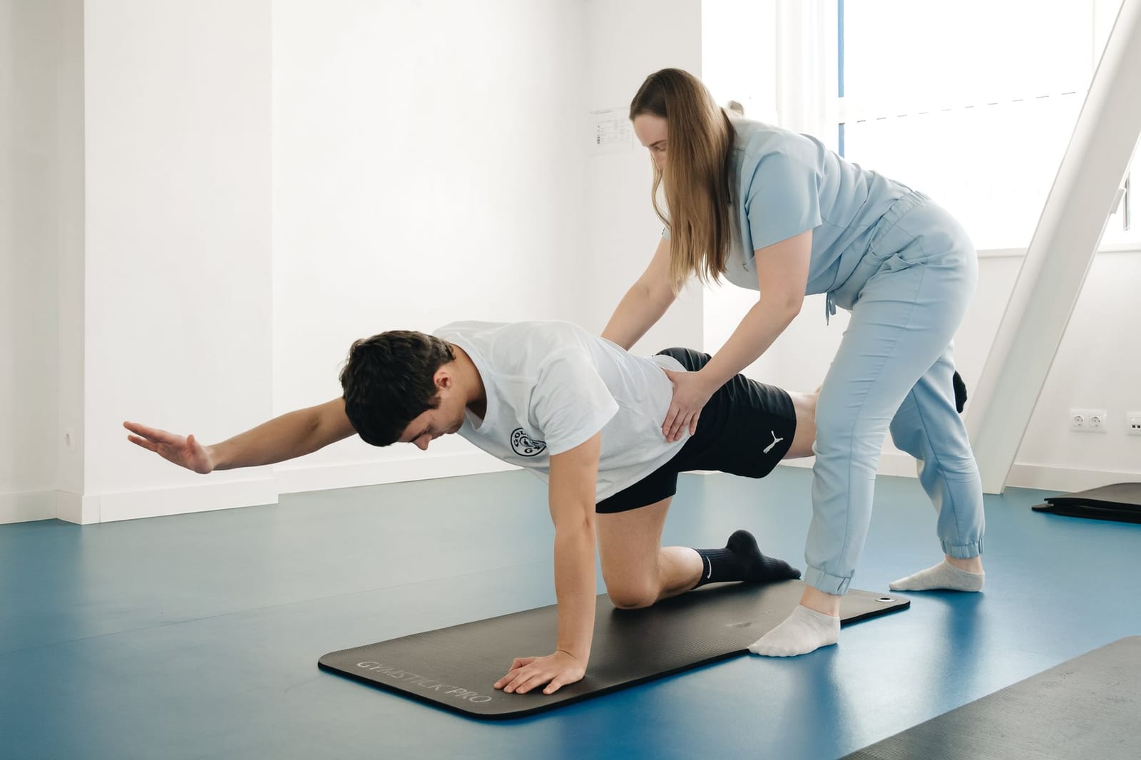 Fisioterapeuta orientando exercício postural com paciente