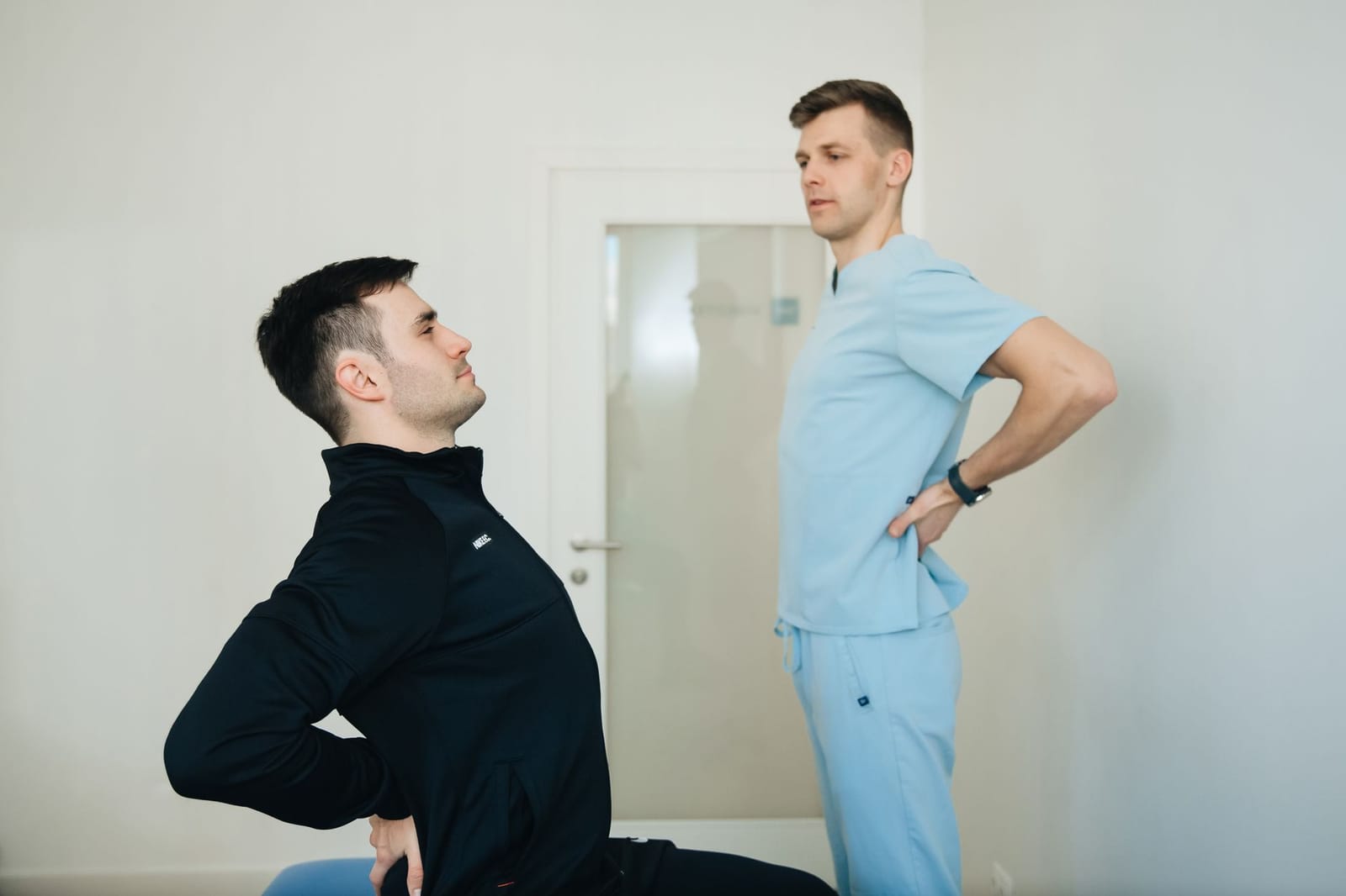 Fisioterapeuta orientando paciente durante exercício de fortalecimento lombar