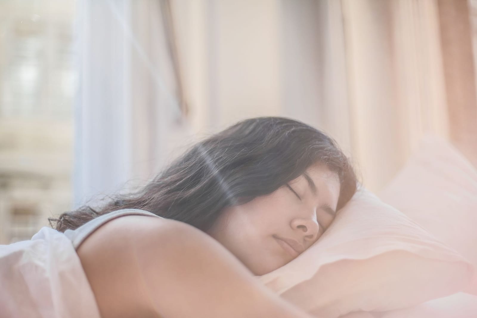 Mulher descansando na cama durante o dia, tentando compensar um sono que não foi reparador